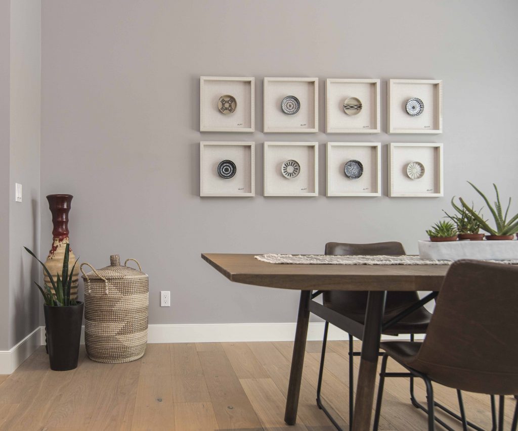 An interior shot of a modern house dining room with art on the wall