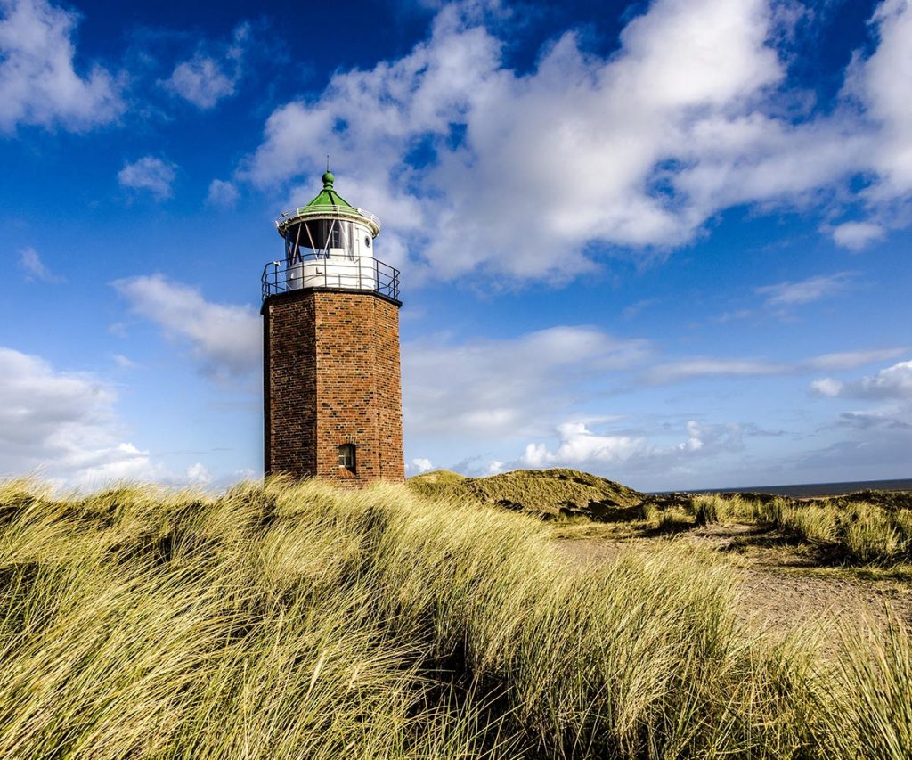 The lighthouse Quermarkenfeuer in Kampen, Sylt, Germany under the cloudy sky