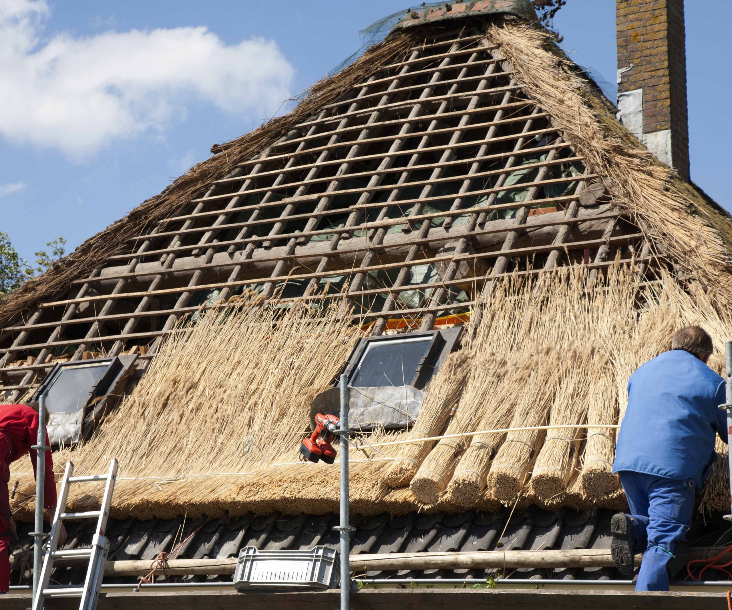 Workmen thatching a new roof